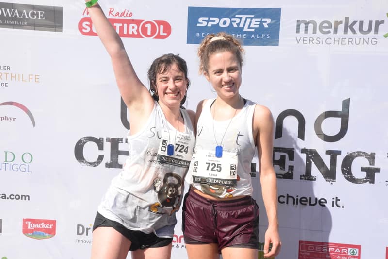 Due finisher esultano davanti alla parete fotografica