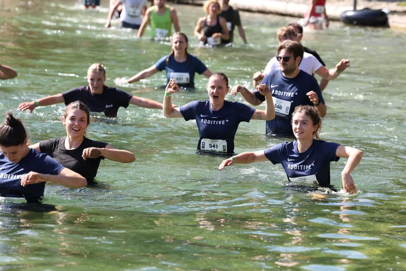 Team aziendale attraversa l'ostacolo d'acqua