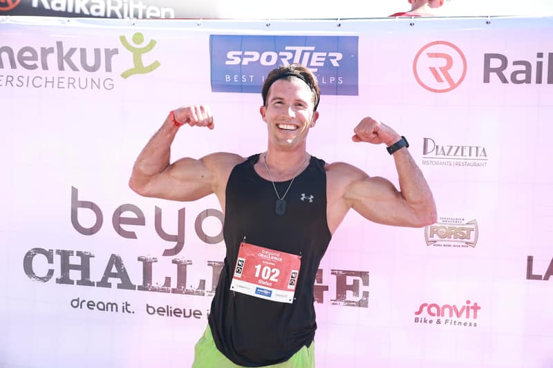 Finisher mostra i muscoli davanti alla parete sponsor